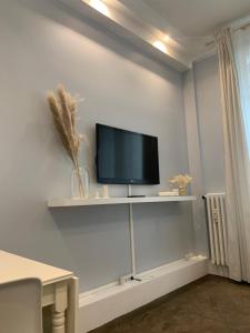 a flat screen tv sitting on a shelf on a wall at Charming Eiffel Tower Appartement in Paris