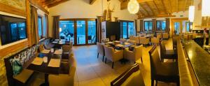 pusta restauracja ze stołami, krzesłami i oknami w obiekcie Ferienhotel Bergland w mieście Arzl im Pitztal