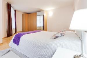 um quarto com uma cama branca e um cobertor roxo em Квартира у Эрмитажа на Наб. Мойки 16 em São Petersburgo