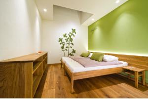 1 dormitorio con cama y pared verde en Majerija, en Vipava