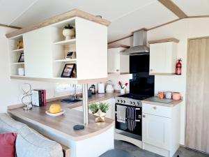 a kitchen with white cabinets and a table in a room at Robin Hood's Retreat in Robin Hood's Bay