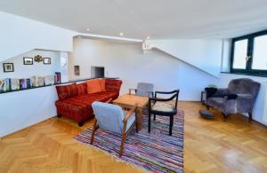 a living room with a red couch and a table and chairs at Spacious Flat with Panoramic View in Vienna