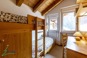 ein Schlafzimmer mit einem Etagenbett und einem Schreibtisch in der Unterkunft Trevisan in Campitello di Fassa