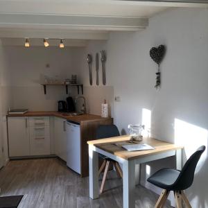 cocina con mesa, mesa y sillas en Kingstreet Cottage, en Zandvoort
