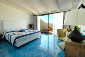 sypialnia z łóżkiem, kanapą i krzesłem w obiekcie Hotel Resort & Spa Baia Caddinas w mieście Golfo Aranci +37 zdjęć