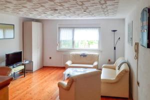 uma sala de estar com duas cadeiras e uma televisão em Terraced house, Kaltennordheim em Fischbach