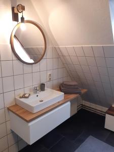 y baño con lavabo y espejo. en Schönes Apartment vor den Toren Hamburgs - keine Monteurwohnung, en Asendorf
