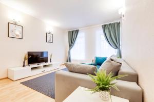 a living room with a couch and a tv at Apartments Uyut in Saint Petersburg