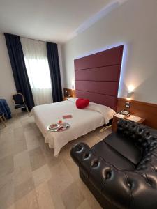 Habitación de hotel con cama y sofá de cuero en Venice Hotel, en Grisignano di Zocco