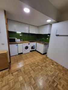 a kitchen with white cabinets and a washer at Apto VIELHA CENTRO Internet fibra in Vielha +18 photos