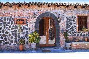 un edificio de piedra con una puerta de madera con macetas en Holiday home Castiglione di Sicilia, en Castiglione di Sicilia