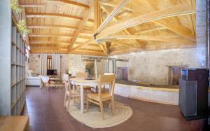 a dining room with wooden ceilings and a table and chairs at El Lagar de La Navazuela in La Rasa
