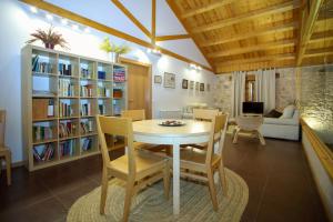 a dining room with a table and chairs and a book shelf at El Lagar de La Navazuela in La Rasa