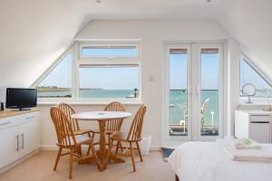 a bedroom with a table and chairs and a view of the ocean at A Spacious Seaside house in Hampton, Herne Bay in Herne Bay