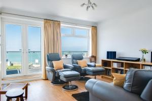 un soggiorno con divano, sedie e una grande finestra di A Spacious Seaside house in Hampton, Herne Bay a Herne Bay