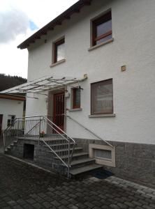 una casa bianca con scale che conducono a una porta di Ferienwohnung Zum Bienenstock a Mörlenbach