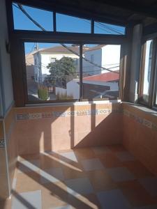 Habitación vacía con ventana grande y suelo de baldosa. en Apartamento Cerro De Las Salinas en Ronda