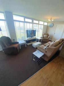 a living room with a couch and a tv at Grand Chalet 64 Disabled Friendly in Skegness