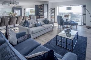 ein Wohnzimmer mit 2 Sofas und einem Tisch in der Unterkunft Sunrise - 5 Bedroom Luxurious Holiday Home - Pendine in Pendine