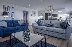 a living room with two couches and a table at Sunrise - 5 Bedroom Luxurious Holiday Home - Pendine in Pendine