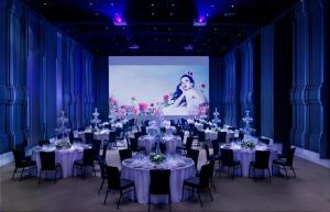 
a room filled with tables and chairs with a projector screen at SO BANGKOK - SHA Extra Plus in Bangkok
