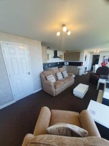 a living room with two couches and a kitchen at Grand Chalet 64 Disabled Friendly in Skegness
