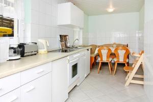 a kitchen with white cabinets and a table and chairs at House, Tessmannsdorf in Teßmannsdorf