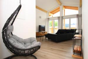 a living room with a hammock chair and a couch at Apartment with sauna and panoramic view in Inzell in Inzell