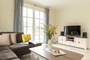 a living room with a couch and a tv at Holiday house, Fuhlendorf in Fuhlendorf