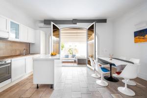 a kitchen with white cabinets and a table and chairs at Casa Malu in Positano