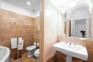 a bathroom with a sink and a toilet and a mirror at Casa Malu in Positano