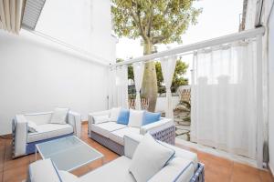 a patio with white furniture and a tree at Casa Malu in Positano