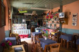 a restaurant with tables and chairs and a bar at Napoleon Zaglis Guesthouse in Kalarrites