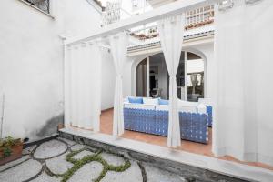 a patio with blue and white furniture on a white building at Casa Malu in Positano