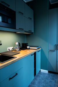 a kitchen with blue cabinets and a counter top at Maya's Flats & Resorts 40 - Kolodziejska 7/9E in Gdańsk