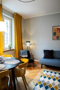 uma sala de estar com uma mesa e um sofá em Maya's Flats & Resorts 40 - Kolodziejska 7/9E em Gdańsk