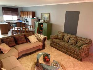 a living room with two couches and a kitchen at Daffodil Self Catering and Accommodation B in Swakopmund