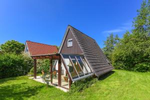 ein kleines Haus mit einem Pavillon im Hof in der Unterkunft Ferienhaus Windspiel in Neuharlingersiel