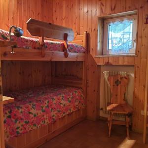 1 Schlafzimmer mit 2 Etagenbetten und einem Stuhl in der Unterkunft Casa Maddalena in Canazei