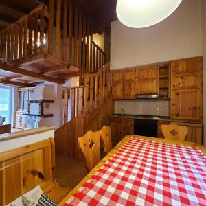 eine Küche mit einem Tisch mit einem roten und weißen karierten Tischtuch in der Unterkunft Casa Maddalena in Canazei