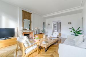 een woonkamer met een bank en een tafel bij Superbe appart de 129m2, 3 ch-Neuilly 2 min Paris in Neuilly-sur-Seine
