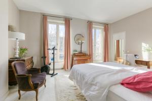 um quarto com uma cama, uma secretária e uma cadeira em Superbe appart de 129m2, 3 ch-Neuilly 2 min Paris em Neuilly-sur-Seine