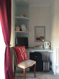 a red pillow on a chair in front of a desk at Rose & Crown in Slaley