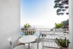 a balcony with a table and chairs and a view of the ocean at Casa Malu in Positano