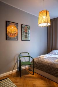1 dormitorio con 1 cama y 1 silla verde en Maya's Flats & Resorts 40 - Kolodziejska 7/9E en Gdansk