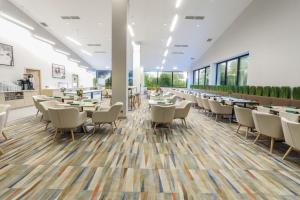 a restaurant with tables and chairs in a room at Magnus Resort in Szczyrk