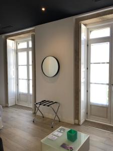 a room with two windows and a table and a mirror at Hotel Montes in Santiago de Compostela