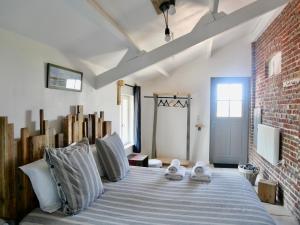 a bedroom with a large bed with a brick wall at Chambres d'Hôtes et Gîte de La Vieille Ecluse in Quend