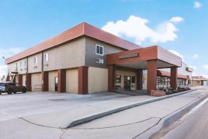 un bâtiment avec une voiture garée devant lui dans l'établissement Coratel Inn & Suites by Jasper McCook, à McCook