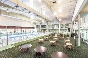 a large room with a pool and tables and chairs at Coratel Inn & Suites by Jasper McCook in McCook